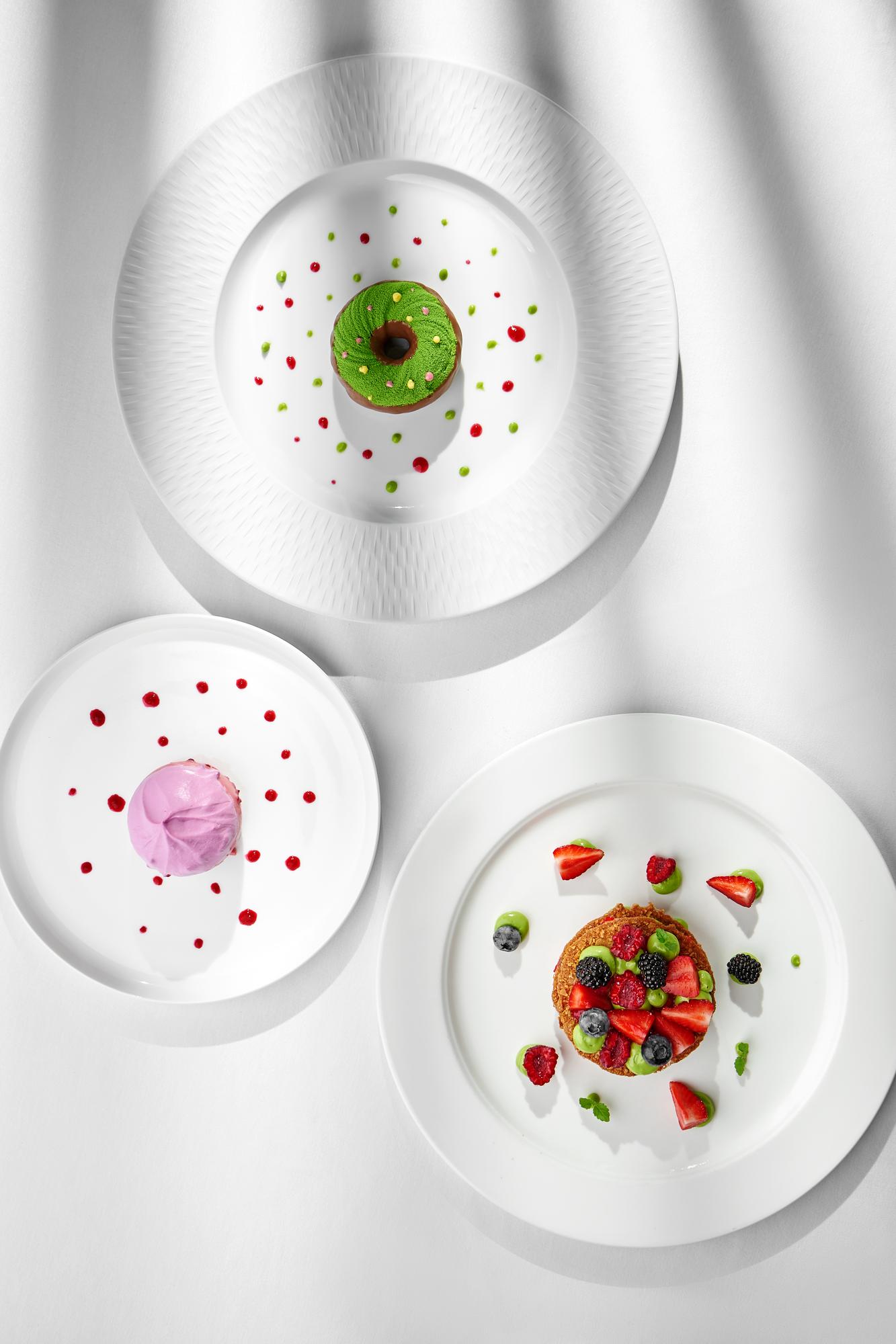 three plated concept dishes on a dark table